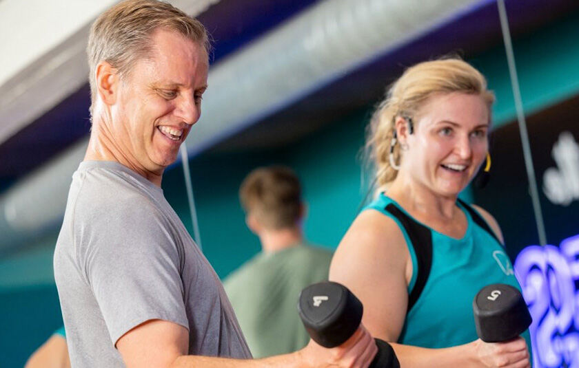 Mand og kvinde som træner med håndvægte i PureGym