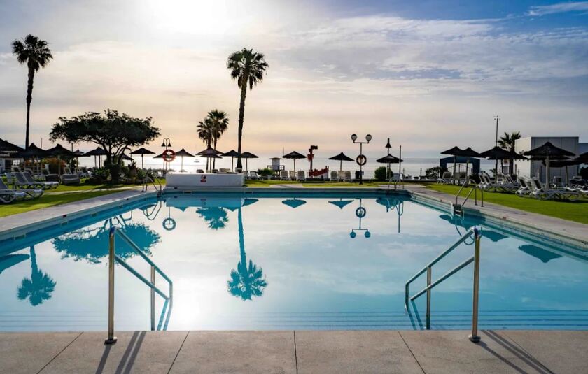 Rejse til Andalusien med Albatros Travel og nyd omgivelser med en pool, palmer og havet.