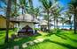 Udendørs spapavilloner på det grønne græs under palmetræerne ved Pandanus Resort i Mũi Né i Vietnam.