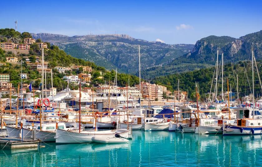 Den maleriske havn Port de Sóller på den nordvestlige kyst af Mallorca i Spanien, smukt omgivet af Tramuntana-bjergene.