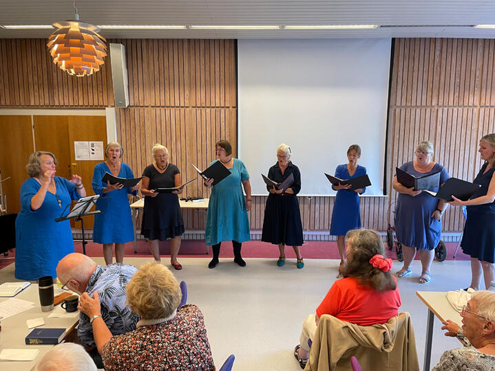 Sigga med sit kor, PAJAvokalensemble, på Rønne Bibliotek. (Foto: Margrit Skott).